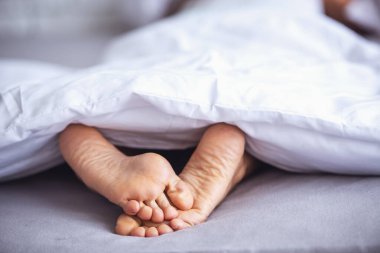 Onun yatağında battaniyenin altında uyuyan kadın güzel metrelik. Arka plan üzerinde yatak odası.