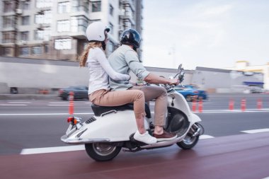 Kask bir scooter sürme güzel genç çift yan görünüm