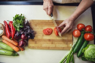Kırpılmış mutfakta yemek yaparken yakışıklı komuta sizde kesim domates Üstten Görünüm