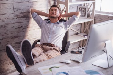 Yakışıklı genç işadamı office sandalyesine dinlenme ve gülümseyen