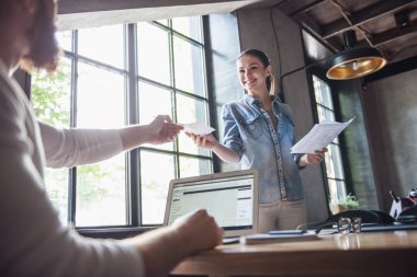 Kadın ve başarılı erkekler ofiste çalışırken bir dizüstü bilgisayarı kullanıyor