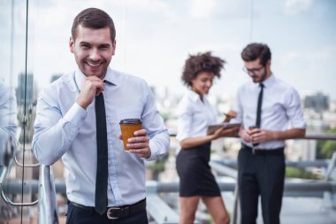 Yakışıklı işadamı ile ön plan üzerinde kahve. İş adamları Balkonda kahve molası sırasında bina ofis iletişim