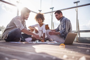 Projeler, kahve içme ve şehir kurma balkonda çalışırken gülümseyen güzel gençler tartışıyor