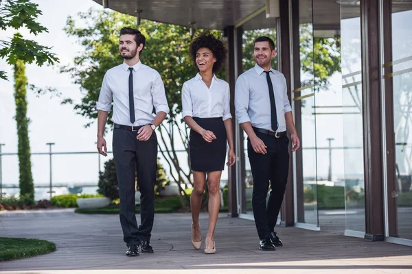 Açık havada yürürken gülümseyen güzel iş adamları tam uzunlukta portresi