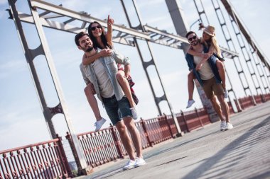 Tam boy görüntü pickaback oturan kız şehirde yürürken eğleniyor neşeli gençlerin