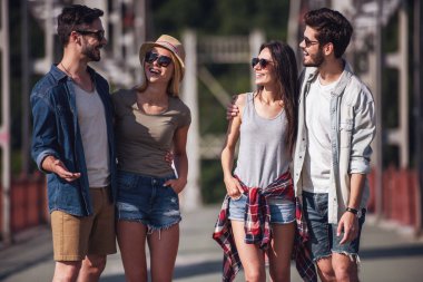 Neşeli Genç çiftler sarılma, söz ve şehirde yürürken gülümseyen