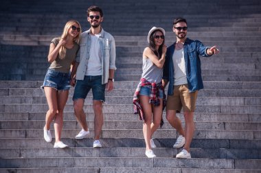 Neşeli Genç çiftler el ele tutuşarak, söz ve şehirde yürürken gülümseyen