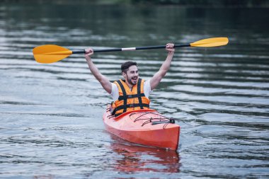 Bir kayık yelken sırasında deniz yeleği yakışıklı genç gülümseyen