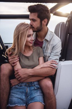 Güzel çift sarılma ve yolculuk sırasında arabalarında istirahat ederken gülümseyen