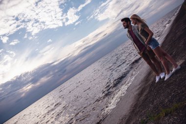 Tam boy görüntü elele ve deniz manzarası eşliğinde gülümseyerek Romantik Çift