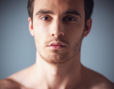 Yakışıklı genç adamın yüzünde gri arka plan kırpılmış görüntü