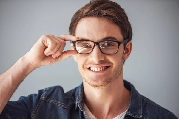 Guapo Joven Ropa Casual Gafas Está Mirando Cámara Sonriendo Sobre —  Fotos de Stock