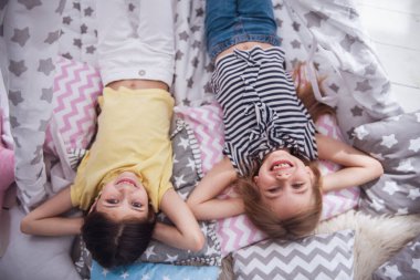 Kameraya bakarak ve birlikte evde oynarken gülümseyen iki sevimli küçük kız Üstten Görünüm