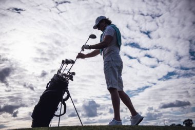 Tam uzunlukta portre yakışıklı adamın bir golf kulübü golf sahası üzerinde dururken seçme