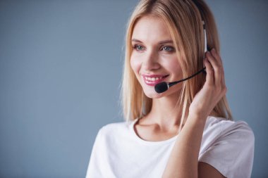 Gri arka plan üzerinde kulaklık güzel genç kadın gülümseyerek