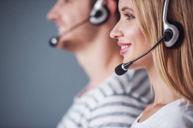 Güzel genç çift gözle ve gri arka plan üzerinde gülümseyen mezartaşı içinde yan görünüm