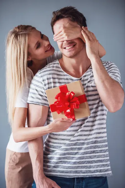 Beautiful Young Woman Holding Gift Box Covering Her Boyfriend Eyes — Stock Photo, Image