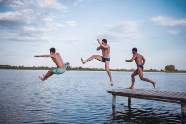 Yakışıklı çocuklar göle, harika bir manzara iskeleden atlama vardır