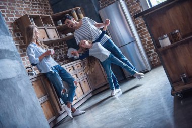 Sevimli küçük kız ve yakışıklı babası dans ediyor, anne çay içiyor, tüm birlikte mutfakta vakit ise gülüyorsun