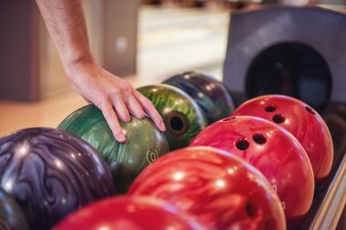 Erkek eli ile oynamaya hazır bir bowling topu seçme