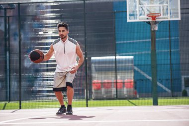 Yakışıklı basketbolcu basketbol sahasına açık havada oynuyor