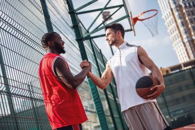 Yakışıklı basketbolcular basketbol sahası açık havada oyun önce tebrik