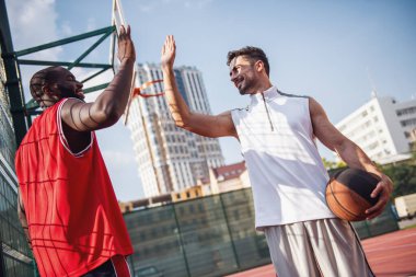 Yakışıklı basketbol oyuncuları tebrik ve basketbol sahası açık havada oyun önce gülümseyerek