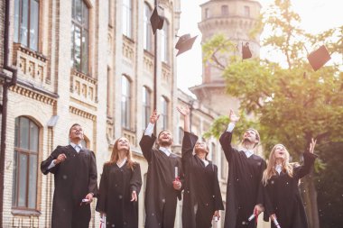 Akademik elbiseler başarılı mezunlar diploma holding, sınırlarına atma ve açık havada duran süre gülümseyen