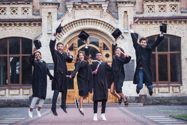 Successful Graduates Academic Dresses Holding Diplomas Looking Camera Smiling While — Stock Photo, Image