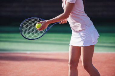 Kız açık havada sahada Tenis oynarken tenis raketi tutan kırpılmış görüntü