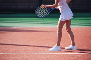 Kız açık havada sahada Tenis oynarken tenis raketi tutan kırpılmış görüntü