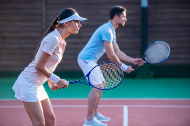 Güzel genç çift takım olarak açık havada tenis kortunda Tenis oynayan