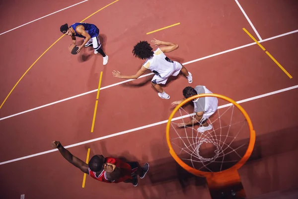 High angle view of handsome guys playing basketball outdoors at night