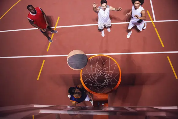 High angle view of handsome guys playing basketball outdoors at night