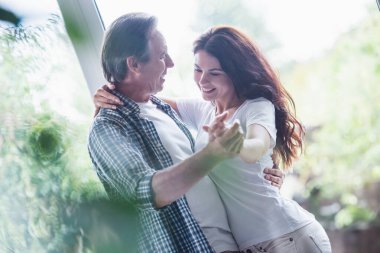 Güzel mutlu çift dans ve evde istirahat ederken gülümseyen