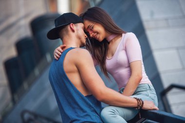 Şık genç çift sarılma ve şehirde yürürken gülümseyen