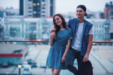 Şık genç çift sarılma, söz ve şehirde yürürken gülümseyen