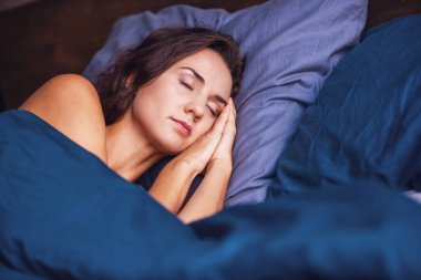 Güzel genç kadın evde yatakta uyuyor