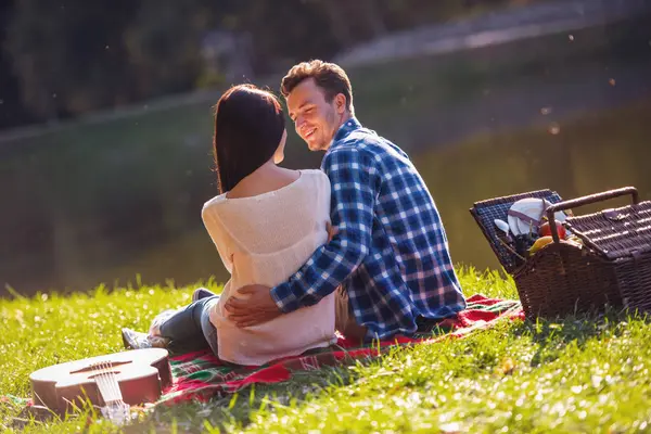 美しい若いカップル話と公園で格子縞の休んでいる間ハグの背面図 — ストック写真