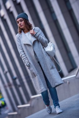 Güzel kız ceket ve şehirde yürüyüş kap tam boy görüntü