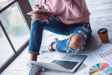 Notları ile bir dizüstü bilgisayar evde çalışırken yapma rahat kıyafetler içinde çekici genç kadın Resim kırpılmış