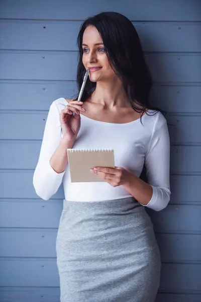 Attractive Young Woman Holding Notepad Pen Thinking Smiling Gray Background — Stock Photo, Image