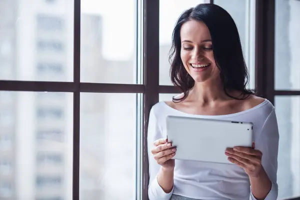 Attractive Young Woman Using Digital Tablet Smiling While Standing Window — Stock Photo, Image