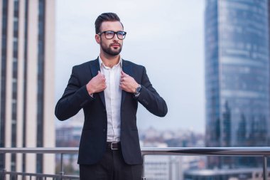 Takım elbise ve gözlük yakışıklı işadamı uzak duran balkonda arıyor