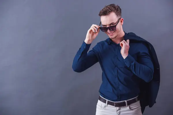 Schöner Junger Geschäftsmann Schicker Freizeitkleidung Und Sonnenbrille Hält Eine Jacke lizenzfreie Stockbilder