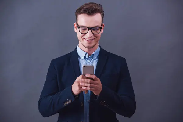 Guapo Joven Hombre Negocios Traje Gafas Está Utilizando Teléfono Inteligente Fotos De Stock