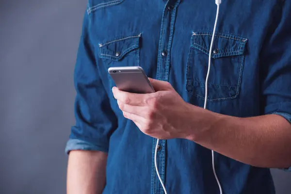 Abgeschnittenes Bild Eines Jungen Mannes Mit Kopfhörer Benutzt Ein Smartphone lizenzfreie Stockbilder
