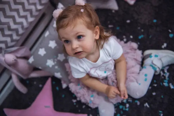 Nettes Kleines Mädchen Spielt Kinderzimmer Mit Konfetti lizenzfreie Stockfotos