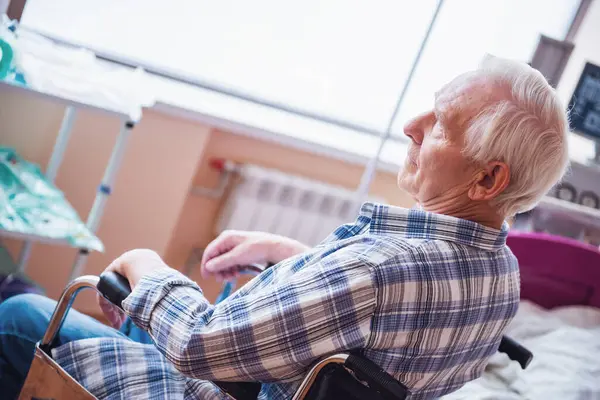 英俊的老人坐在轮椅上在医院病房里微笑着 — 图库照片