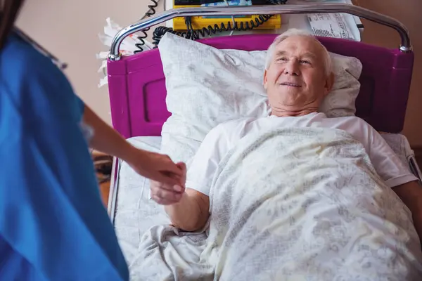 Vrolijke Oude Man Zoek Naar Verpleegkundige Holding Haar Hand Glimlachen Stockafbeelding